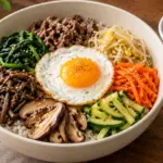 채소와 나물, 익힌 소고기, 달걀프라이를 밥 위에 올린 비빔밥과 별도로 담은 고추장