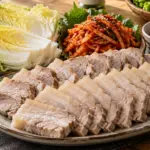 삶아 썬 돼지고기에 배추와 무채, 양념을 따로 곁들인 보쌈