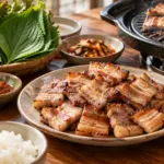 익힌 삼겹살과 상추, 깻잎, 쌈장, 마늘과 밥을 따로 담은 상차림
